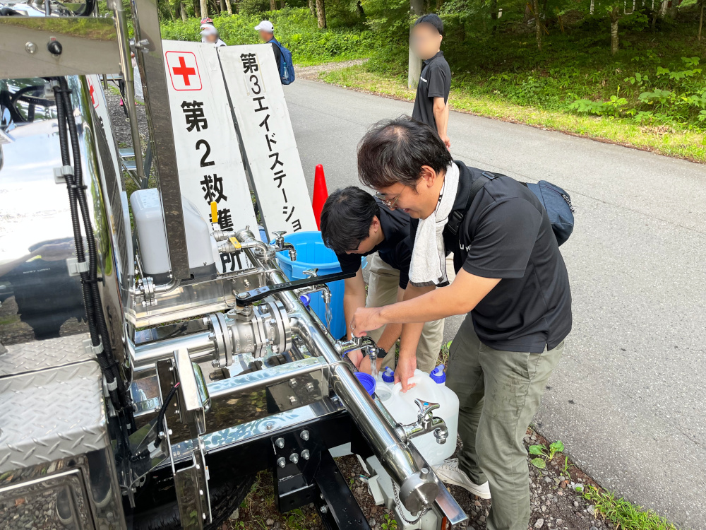 給水車からタンクへ水を入れている写真