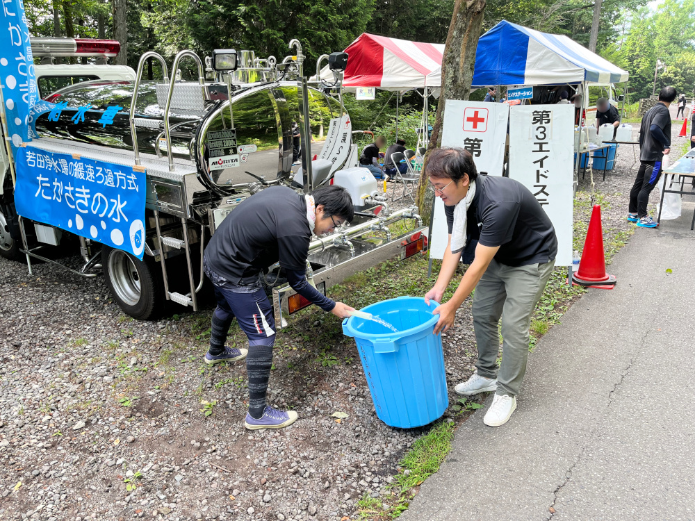 給水車からバケツに水を入れている写真